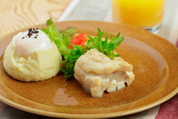 Mashed potatoes with egg yolk and fish slice