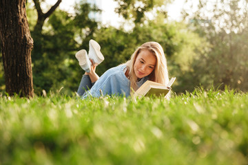 Portrait of a cute young girl laying on a grass at the park