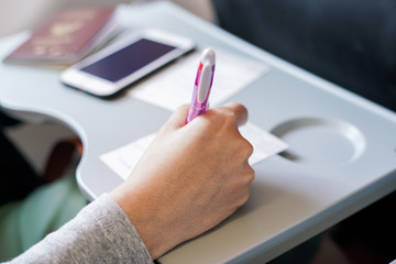 Hand Filling Immigration Form On Flight