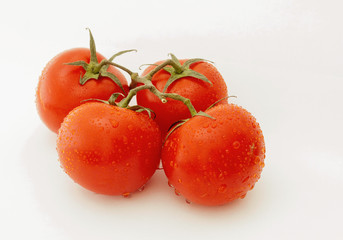 four beautiful tomatoes on a white background