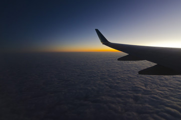 Fototapeta na wymiar paisaje de atardecer sobre las nubes con ala de avion en primer plano