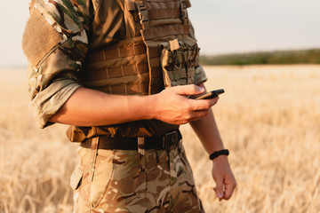 Mid section of military soldier using mobile phone in boot camp. letter from war. - Powered by Adobe