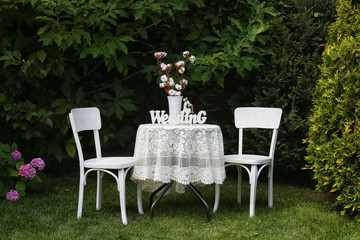 A table for two, with a white tablecloth on the nature, with an inscription wedding