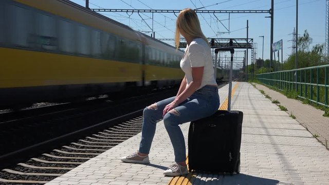 A young beautiful woman waits for a train
