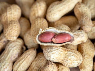 Closeup dried peanuts in shells on peanuts background on wooden table. Concept of snack