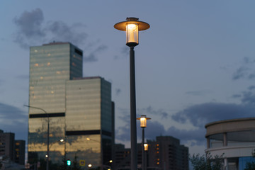 Street lamps light at the sunset. Image with defocused background