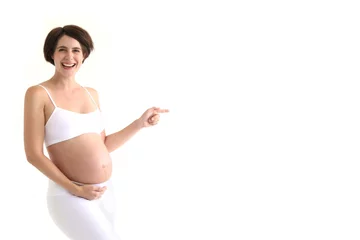 Fotobehang Schwangere Frau zeigt lachend in eine Richtung © Joerch