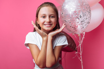 portrait of a girl with balloons in the Studio, on a pink background, close-up