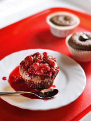 Brownie with mixed red berries topping on a red serving tray