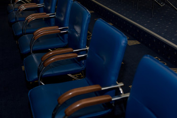 the interior of the exhibition hall. row of blue chairs. blue office chairs. blue leatherette chairs