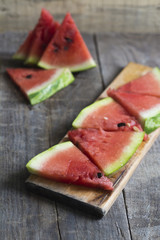 Several pieces of ripe watermelon on a wooden surface.