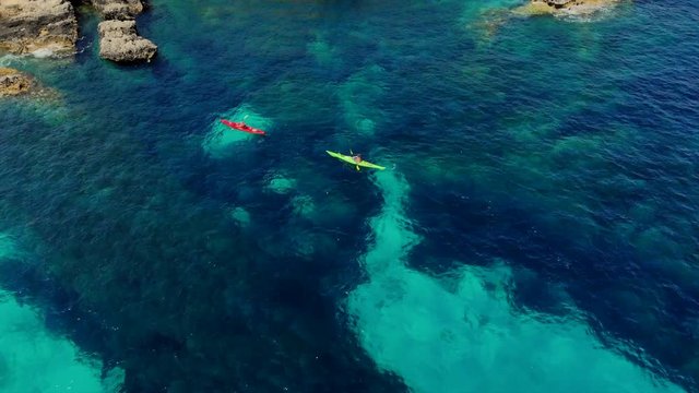 Flying above two kayaking people. The overhead shot emphasises the dark blue and light blue pattern of the sea, giving the shot an incredible feeling.