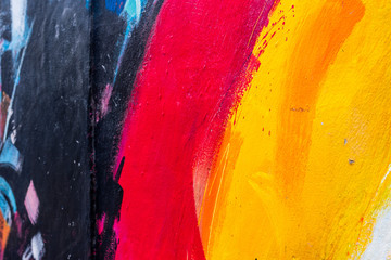 Some abstract colours painted on a wall, red, yellow, black