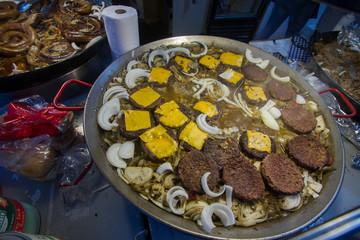American Street food in cooking wok Cheese burgers and onions