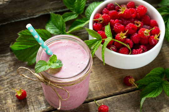 Raspberry milkshake or smoothie on a white wooden background. Healthy juicy vitamin drink diet or vegan food concept.