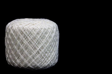 White yarn in roll on black background.