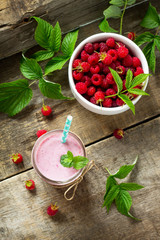 Raspberry milkshake or smoothie on a white wooden background. Healthy juicy vitamin drink diet or vegan food concept.