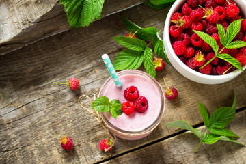 Raspberry milkshake or smoothie on a dark wooden table. Healthy juicy vitamin drink diet or vegan food concept. Top view flat lay background, copy space.