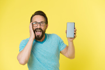 Fantastic application. Guy eyeglasses overwhelmed by new smartphone application. Man bearded happy...