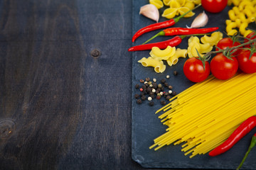 Different pasta on a wooden background.