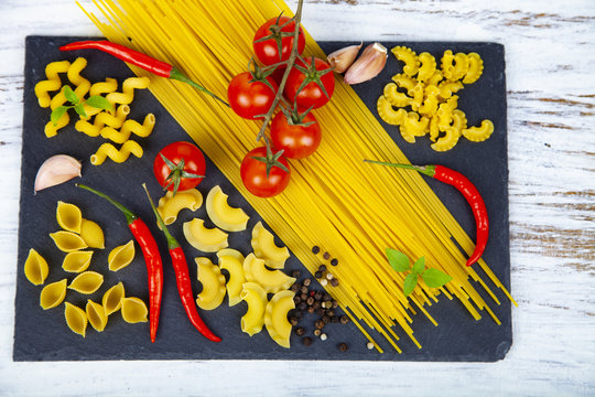 Raw pasta, chili, tomatoes and basil