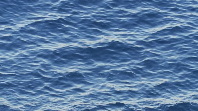 Seamlessly looped water surface texture, calm blue sea waves background, natural ripple  water movements, close up camera view.