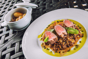 delicious grilled pork loin with mushrooms sauce served on white plate with grilled potatoes, modern gastronomy, product photography for restaurant