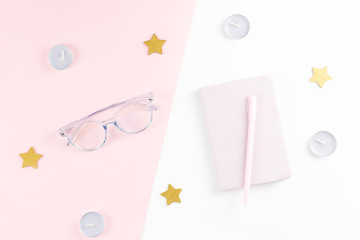 Flat lay home office desk. Female workspace with planner, eyeglasses, candles.