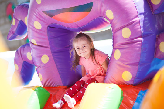 A cheerful child plays in an inflatable castle