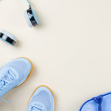 Woman sneakers, headphones, sport bag on pastel background. Sport fashion concept. Flat lay © Maria Shchipakina