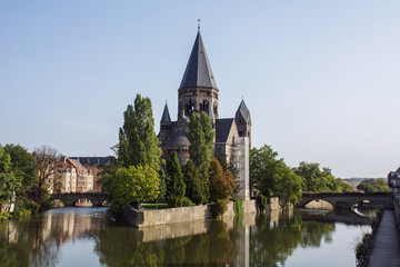 Fototapeta na wymiar Grey french castle in Metz in the summer day with green trees around it near the river