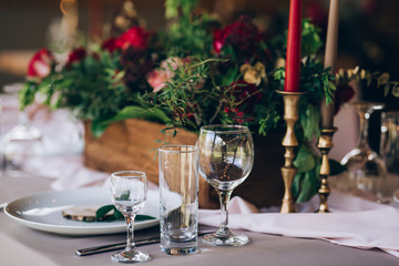a wedding table with cutlery, candles and flowers.
