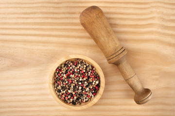 An overhead photo of a mix of various peppers with a pestle, with copy space