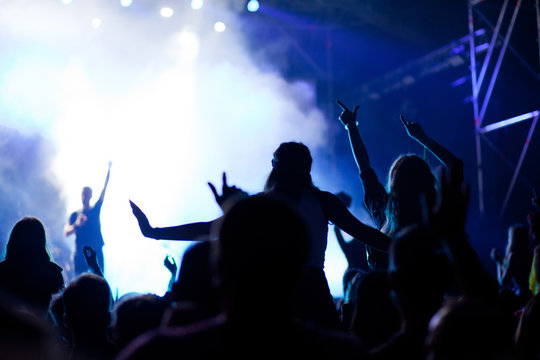 cheering crowd with raised hands at concert - music festival