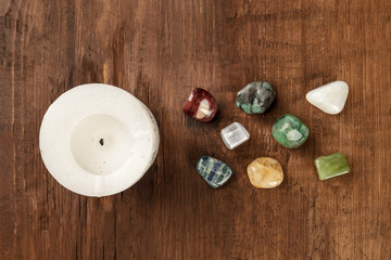 Fototapeta na wymiar An overhead photo of gemstones with a candle, healing stones