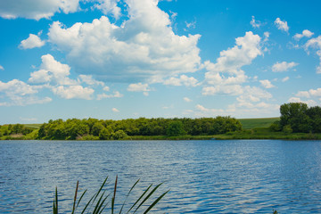 Fototapeta na wymiar Beautiful blue sky with clouds above the lake