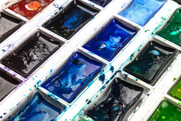 Closeup of vibrant watercolor box with wet paint