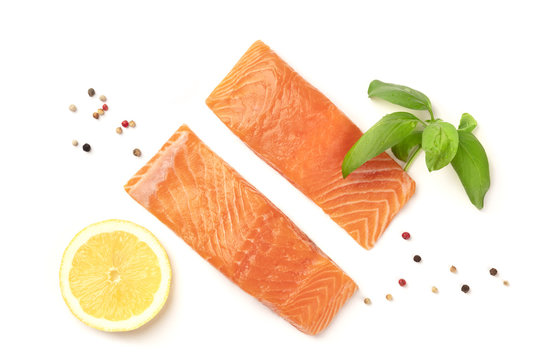 Slices of salmon with lemon, basil, and pepper, on a white background with copy space, overhead photo