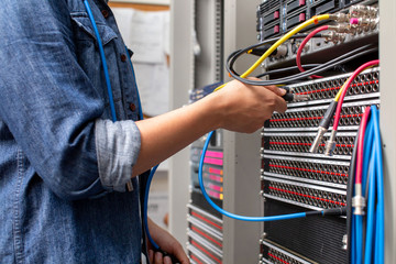 Young man connecting wire video in path panel that is equipped for broadcast.