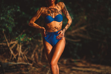 Fototapeta premium Beautiful young woman in a bikini in the shade under the tree