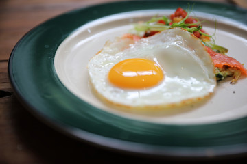 Zucchini fritters with egg and smoked salmon on wood background vinage style