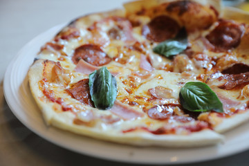 pepperoni bacon and ham pizza in restaurant background