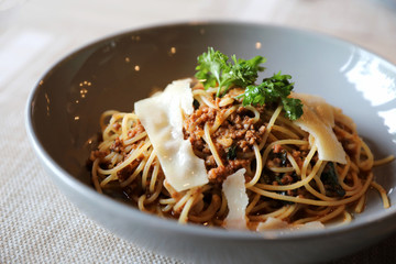 spaghetti Bolognese with minced beef and tomato sauce garnished with parmesan cheese and basil , Italian food