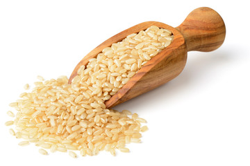 raw brown rice in the wooden scoop, isolated on the white background