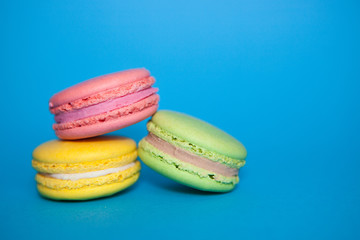 Colorful macaroon biscuits on blue background, beautiful sweet food