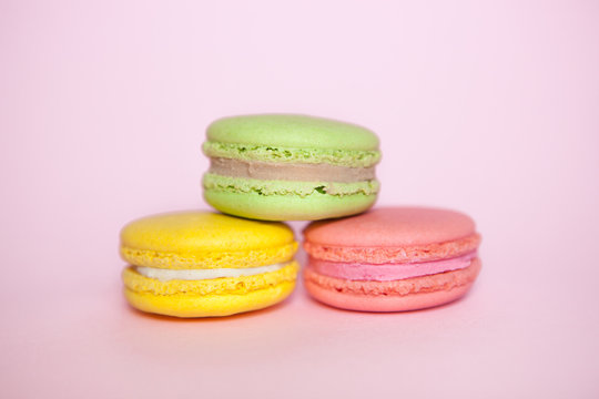 Three colors macaroon biscuits on pastel pink background