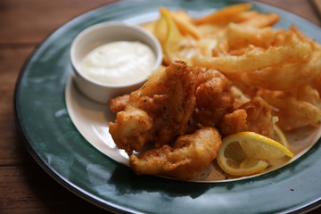 Fish and chips fried fish and potatoes on wood background vintage style