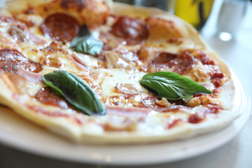 pepperoni bacon and ham pizza in restaurant background