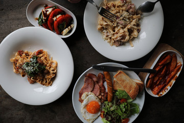 food flat lay top view with pasta and english breakfast on wood background