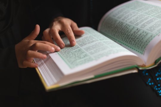Muslim mother and daughter reading holy Quran